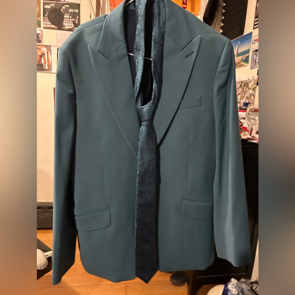 Suit with blazer, pants, tie and its protective bag to store the suit.